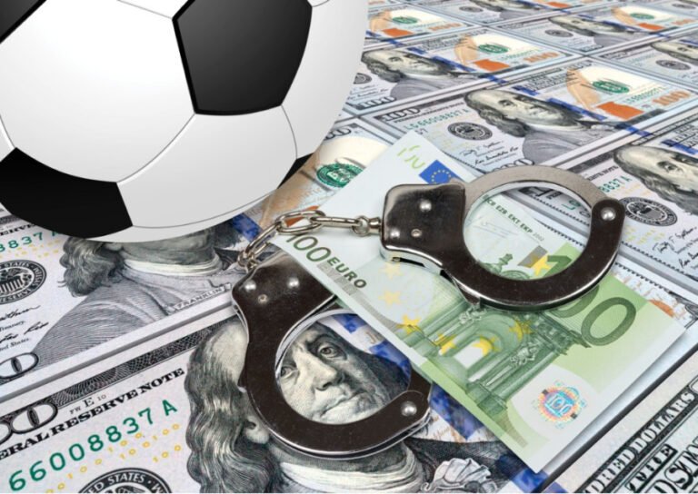 soccer_ball_and_handcuffs_on_pile_of_cash_297258e2a595903a4972ee015a143961